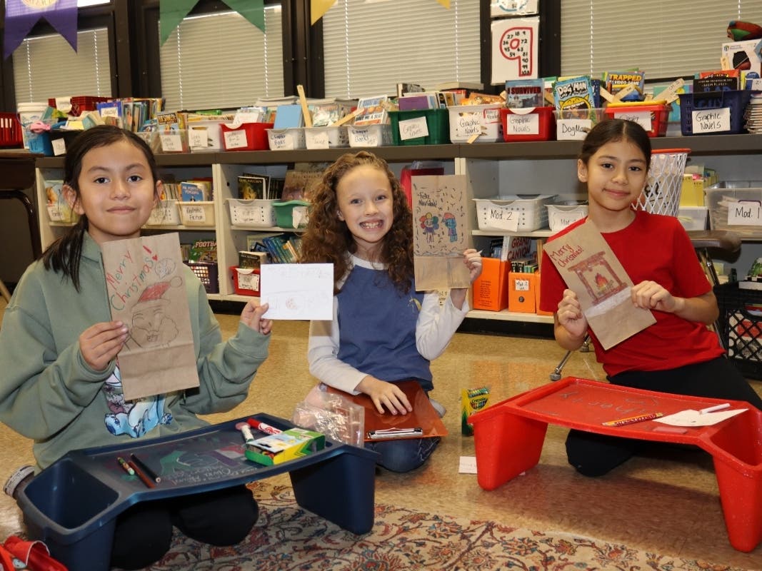 (From left to right) Fourth graders America Ornelas, Grace Boykin and Jessica Diazdeleon personalized bags with drawings and kind words.