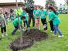 (From left to right) Lynne Thigpen Elementary School second-grade students Adrian Palmerin, Fernando Chacin Castellano, Romina Mendez, Jaxtyn Thompson, Symora Michalek, and Ariyah Lloyd help plant a new tree at their school. 
