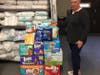 Bare Necessities president Tina Bascom points to a stack of diapers and wipes collected to date by the Guilford Police Department. 