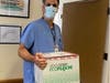 CT Hospice Director of Pharmacy James Prota carries in the Moderna COVID-19 vaccine.
