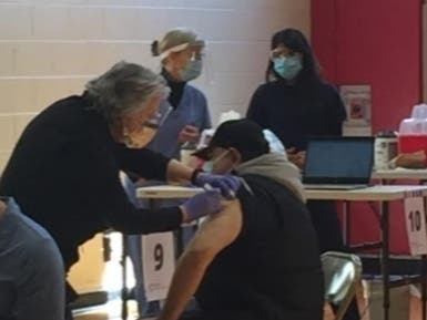 A man is vaccinated against COVID-19 at a Fair Haven Community Health vaccine clinic.