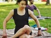 Nina Tsialas, with Ben Shanbrom in the background, practicing yoga. 