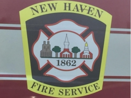 Trapped on the second floor of a Shelton Avenue house on fire, a woman escaped by shoving an air conditioner out of a window, and jumped to safety, the New Haven Fire Department tweeted early this morning.