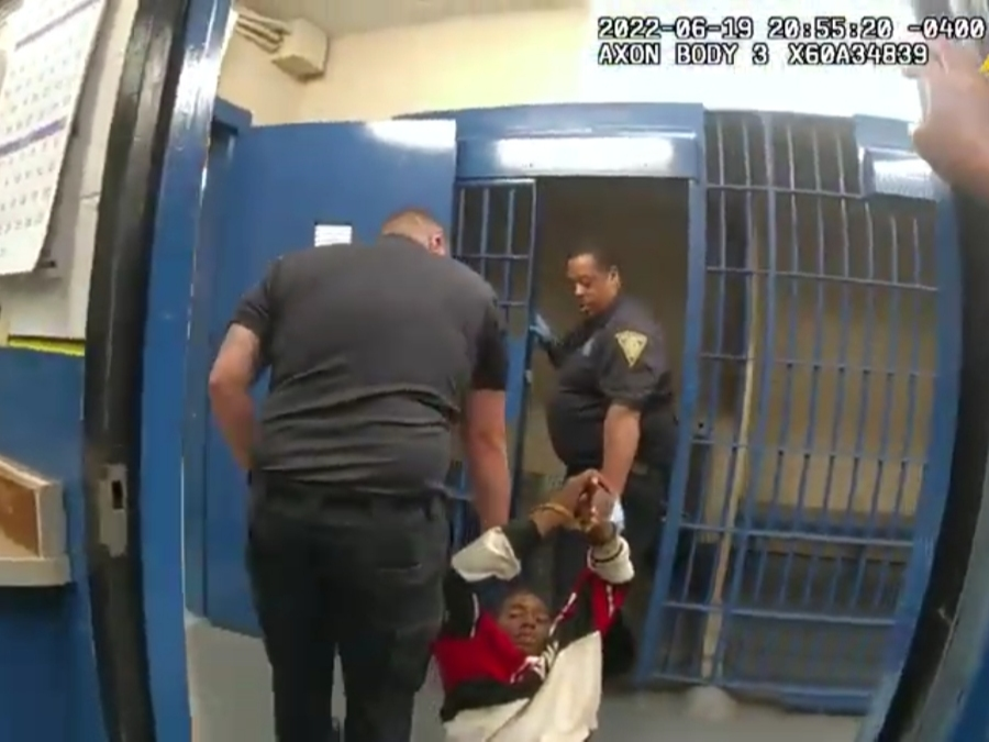 After being booked, Richard Cox, 36, is dragged to a cell by two officers and left on the ground with ankle cuffs placed on him.