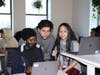 Diego Tardio, associate software engineering educator, reviews projects with DAE students Nadia and Tista. New Haven students "don’t have to pass a test or submit grades to get in."