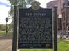 New Haven sign reads: "The 1840 Amistad trial, in which 52 black slaves, who had been mutant need aboard a Spanish slave ship of that name after being kidnapped in Africa in defiance of law, were cleared of all civil charges brought against them."