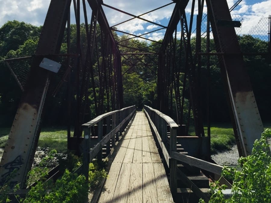 The charming and celebrated iron bridge of the Stony Creek Trolley Trail includes vistas of the Thimble Islands archipelago.