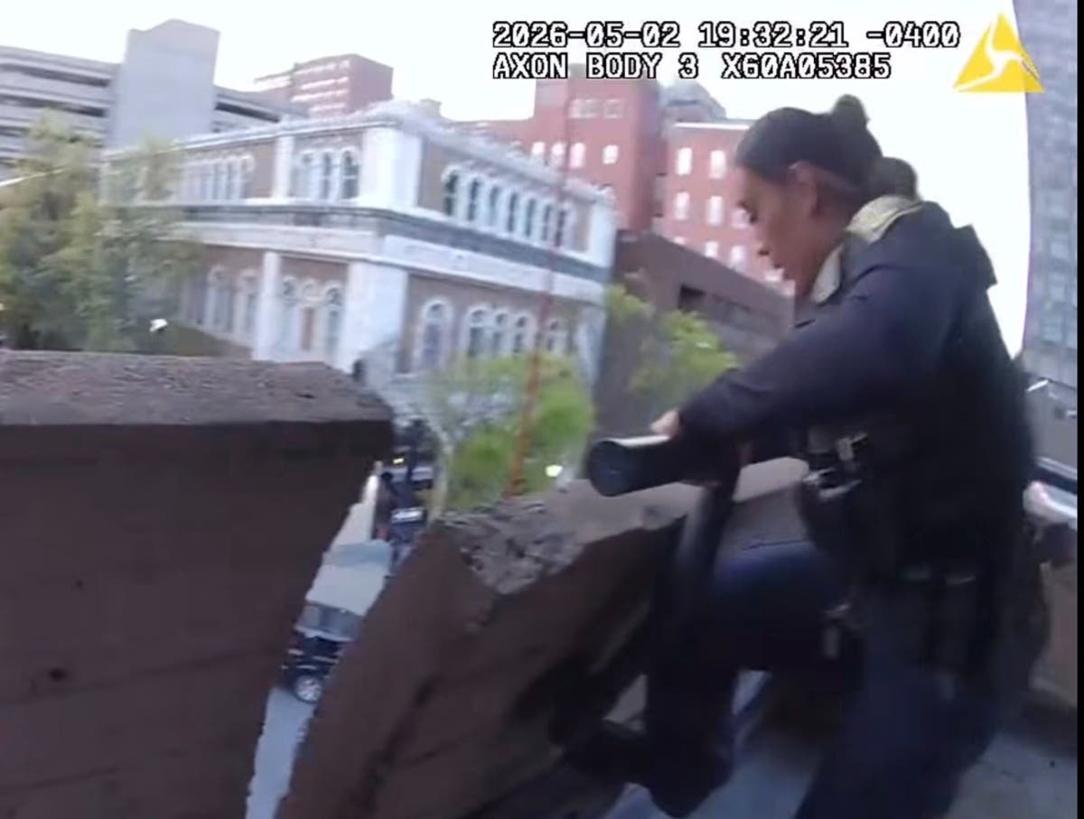 NHPD police officer Mary Ruiz is seen in the video running toward where the man is on the third floor of the Temple Street garage, where she immediately climbs up the railing and leans over the ledge herself, grabbing a rope to help rescue him. 
