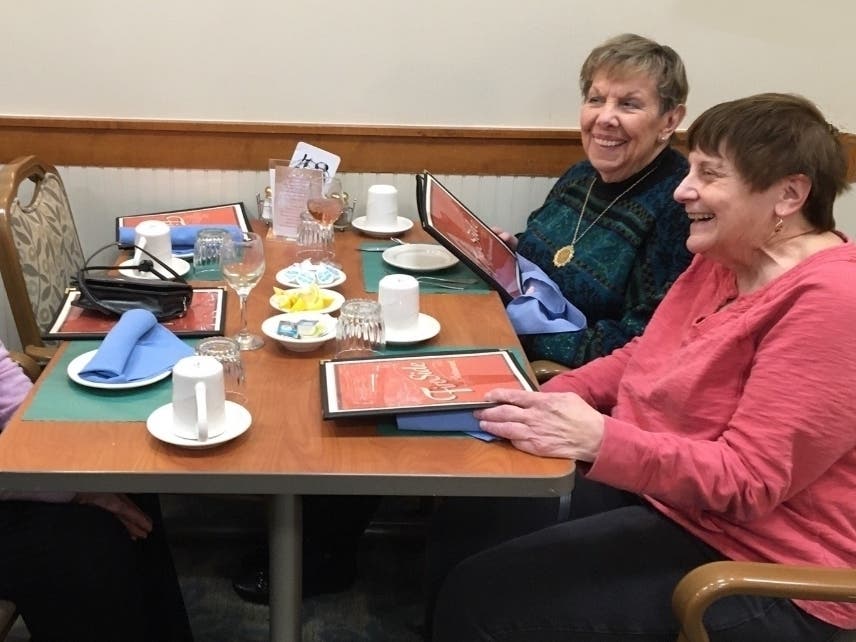 Ann’s Choice resident Ellen Matter (pink shirt) enjoys dining with friends at the Fireside Restaurant on campus. 