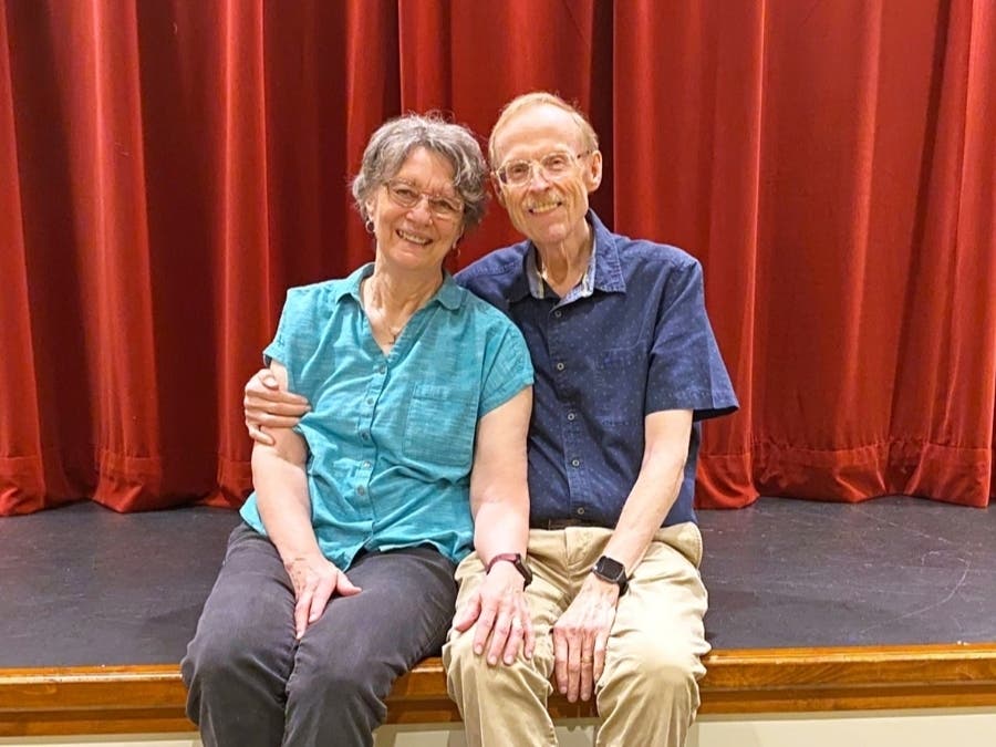 Al and Linda Johnson sit in the Cardinal Theater, where Al enjoys participating in the Maris Grove Players, drawing on his writing and theater background to plan the productions, sets, sketches, and scripts.