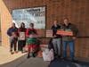 A&T Chevrolet-Subaru management team presents EMC staff with Secret Santa gifts for two student families.