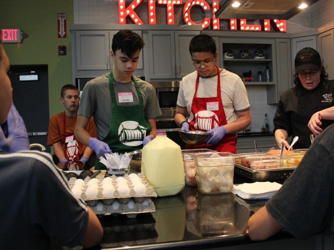 Bridge Teen Center students, Brandon Switalski (left) and Ismael Diaz (right) work together to make an omelette during a free program in the Bridge Kitchen. 