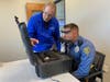 Joe Collins, left, assists with the EyeGuide Concussion Screening for officer McLaughlin, of Harrison Township. 
