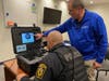 Officer M. Martinez, left, takes the 10-second concussion baseline screening, with Joe Collins assisting.   
