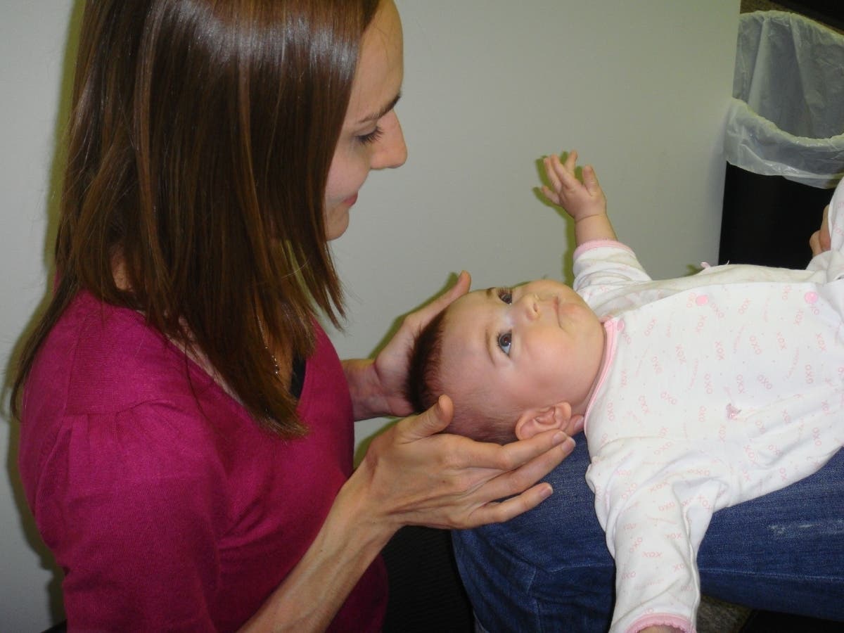 Dr. Katie Sleigh is pictured treating an infant patient.