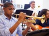 Male Pupil Playing Trumpet In High School Orchestra