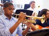Male Pupil Playing Trumpet In High School Orchestra