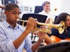 Male Pupil Playing Trumpet In High School Orchestra