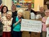 Tradition of Hanover residents and staff pose with a $300 check and the boxes of donated items before being delivered to the Valor Clinic Foundation on Wednesday, Feb. 26
