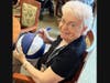 Resident Nancy Gutek signs the honorary basketball the community gifted Bill
