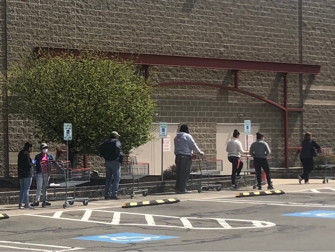 Shoppers in Norwalk practice social distancing while waiting outside of a store.