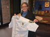 Georgiana Stavrolakes holds a custom chef's coat the Fairfield Police Department gave her to thank her for cooking treats for officers.