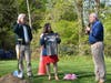 Mike Howard, right, of the Grinning Gravers gravestone restoration group, presents First Selectperson Christine Vitale with a commenrative t-shirt. Michael Jehle, Executive Director of the Fairfield Museum, looks on while holding the time capsule.