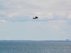 A company-owned Sikorsky UH-60 Black Hawk helicopter on Friday hovers over Penfield Reef in Fairfield, the site of the world’s first successful helicopter hoist water rescue in 1945.