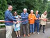 Fairfield Conservation Director Tim Bishop, First Selectperson Christine Vitale and Conservation Commission Chair Luke Thomas cut the ribbon near the new litter boom installed in the Rooster River in Fairfield.