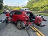 Two people were ejected from this vehicle, and a third person was trapped inside, after it crashed into a guardrail Sunday in Norwalk, according to fire officials.