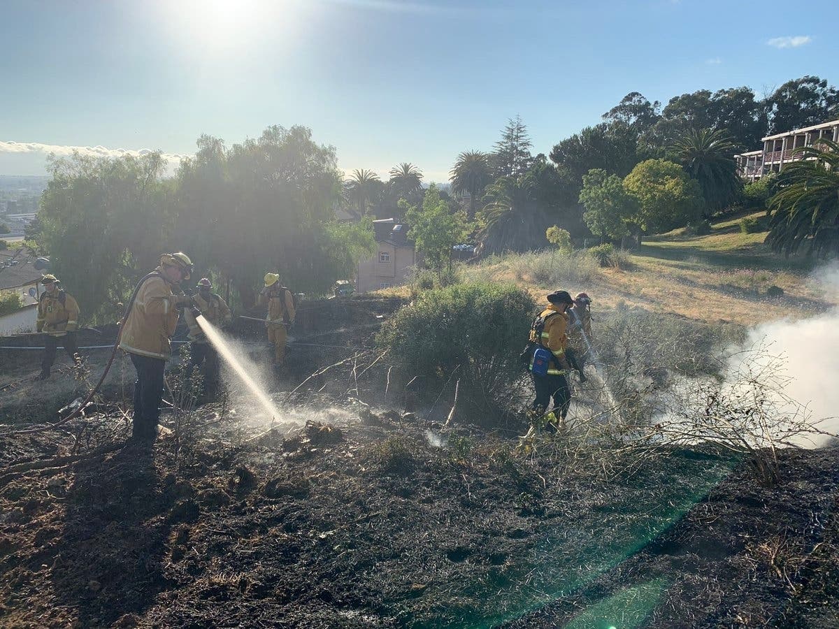 Firefightersspray water on a wildland fire in Ashland on Wednesday