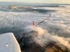 Fog rolling in over the Golden Gate Bridge with San Francisco in the background.