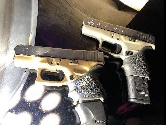 Two guns seized during a traffic stop from two felons.