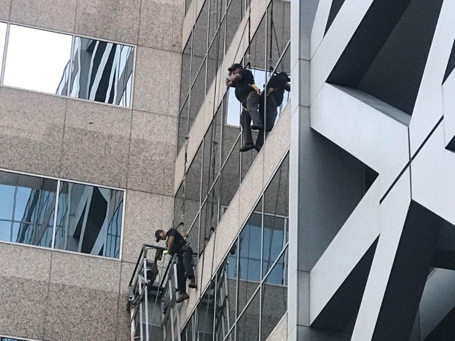 Both men dangled from the building until the fire department performed a high-angle rescue to safely lower the men.