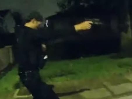 An officer holding his gen, following the shooting.