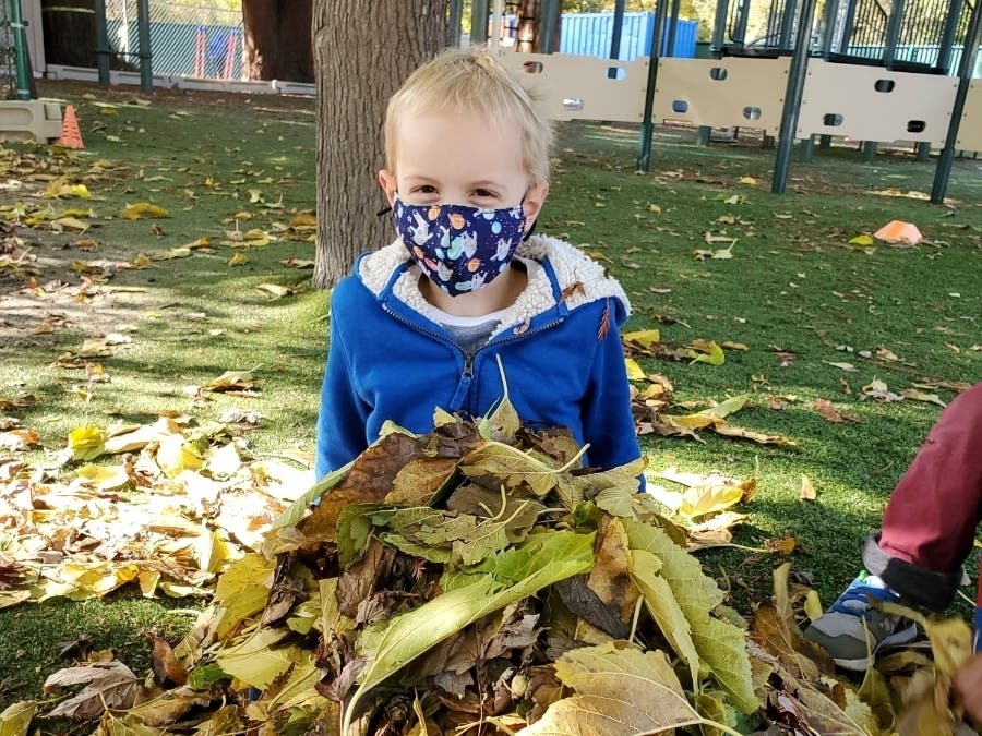 A kindergartener enjoys autumn leaves in Moraga, Calif.