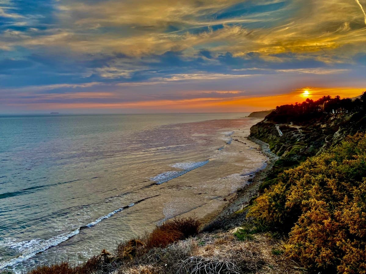 Waves crash near Point Fermin Park as a beautiful summer sunset lights up the sky.