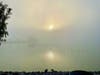 The sun barely cuts through dense morning fog at Lake Elizabeth in Fremont, Calif.
