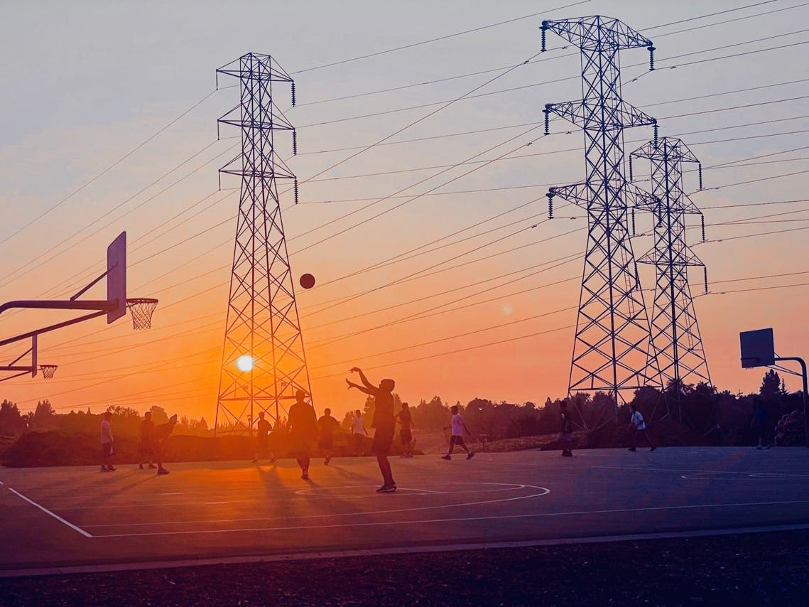 The sun sets behind high tension transmission lines in Fremont, Calif.