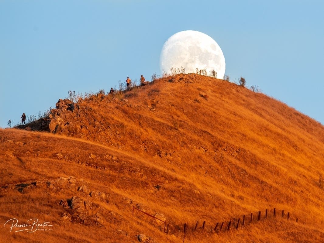 A full moon rises behind Mission Peak in Fremont, Calif.