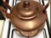 A shiny copper kettle.