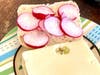 A Swiss cheese and coin-shaped radish sandwich.