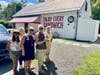 The author's travel companions posed by the Circle W Market -- and its Warren Zevon quote urging visitors to "Enjoy Every Sandwich." 