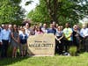 Friends, family and dignitaries stand near the marker named the Maggie Crotty walking path.