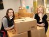 Andrea Egan, Chair of the Board of Directors of the Bergen Volunteer Medical Initiative, and Amanda Missey, President and CEO of Bergen Volunteer Medical Initiative, prepare to deliver emergency meal kits to the organization's patients.  