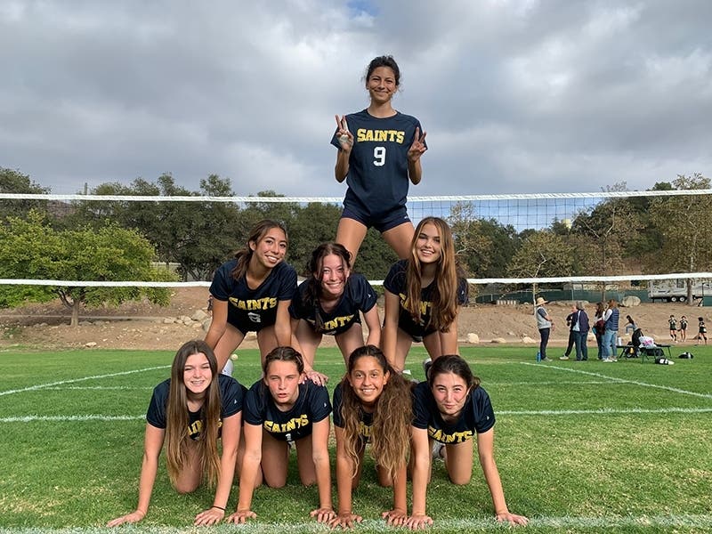 Dahlia on top of the pyramid of some of her friends on the Lighthouse Christian Academy volleyball team.