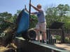 Student Michael Byrne doing his part of cleaning up the facility by disposing of the contents of a wheelbarrow.