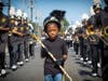 A young community member joins the Uniondale High School marching band on their march to victory. 