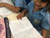 A student from the Ce Corajon De Maria School in San Salvador, El Salvador proudly shows off her classwork assignment. 