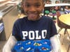 Austin Halstead, grade 1, holding crayon bits that are about to be melted down to create new multi-colored crayons for a lesson on recycling in the brand-new Innovation Lab.